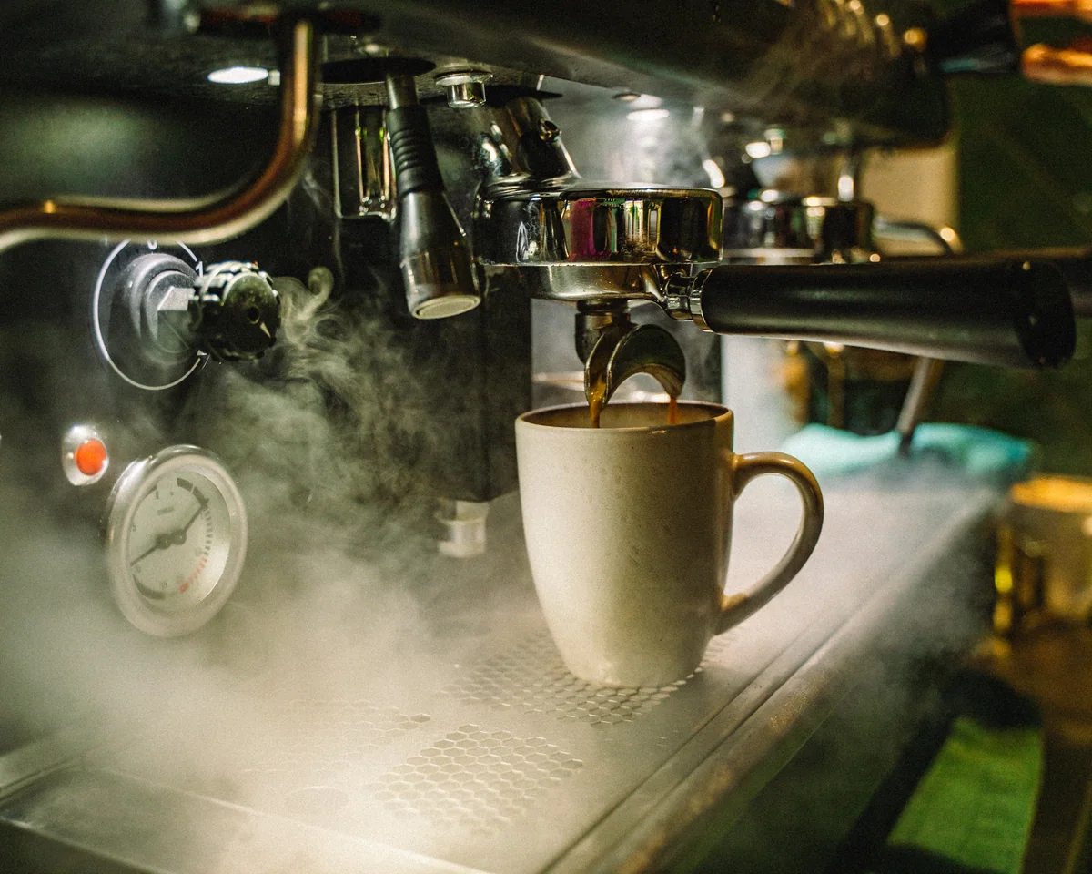 Frischer Espresso läuft aus dem Siebträger in eine Tasse