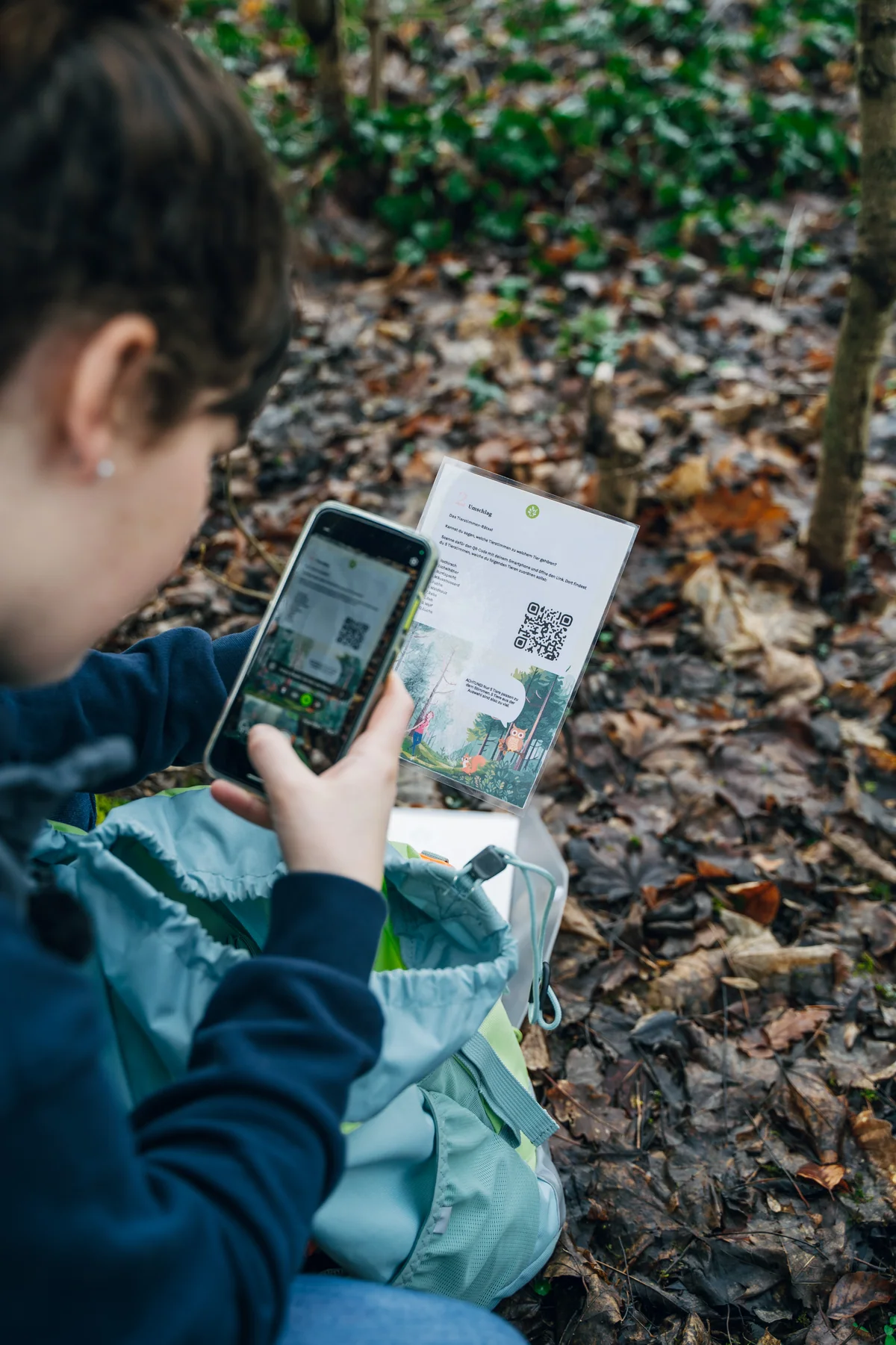 Eine Person scannt den QR-Code der Rätselkarte mit dem Smartphone