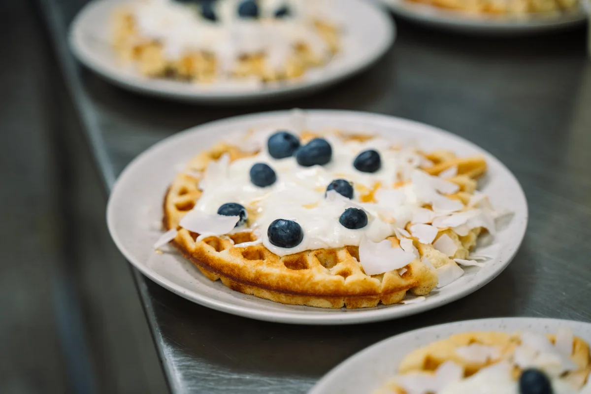 Waffel mit Blaubeeren und Kokosflocken auf einem Teller